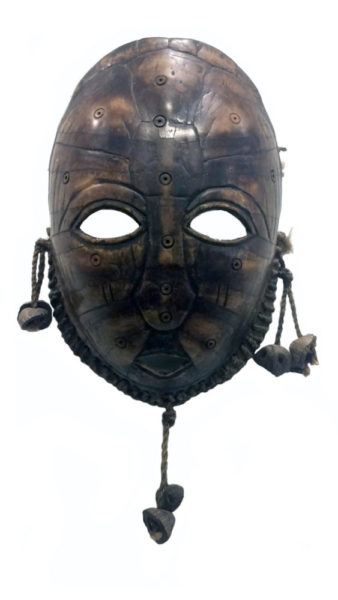 African Mask2 edit whiteout “Face” Lega Mask, Congo, artist unknown, Bwami society. Carved turtle shell, rope, seeds. Collection of Frederick Kramer. The mask is a dark black and brown with eye holes. Stones dangle from the ear and chin areas.