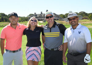 Men and woman gathered around on a golf course for WheatonArts golf classic.