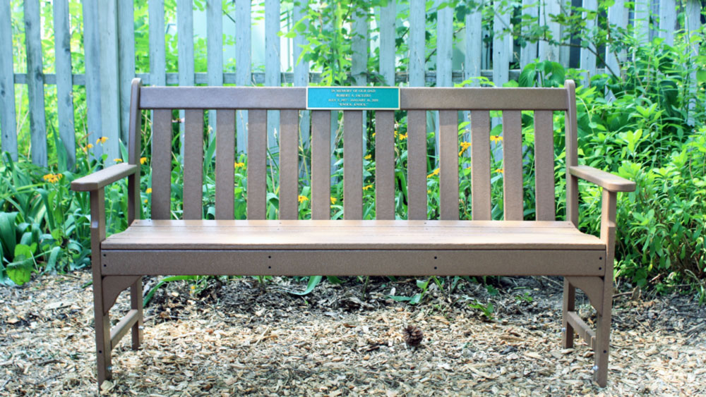 Brown bench with an "in memory of" plaque on the top.