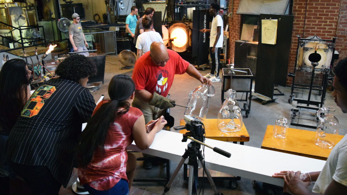 Emanation 2017 artist Therman Statom working on glass face jugs while answering student questions