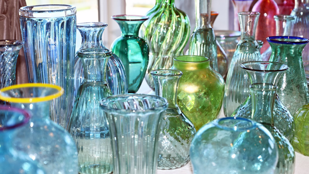 Variety of green, blue, and pink glass vases.