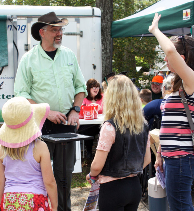 Magician Bill Kerwood surrounded by children.