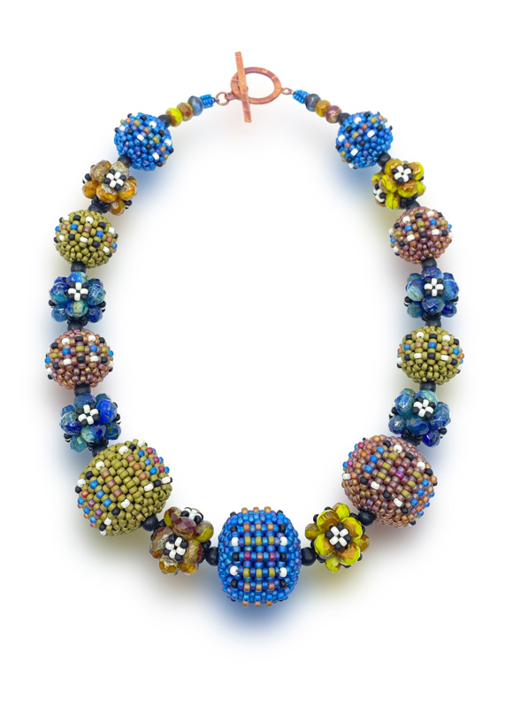 A necklace by artist Sheila Fernekes with colorful beadwork in blue, yellow, and tan,