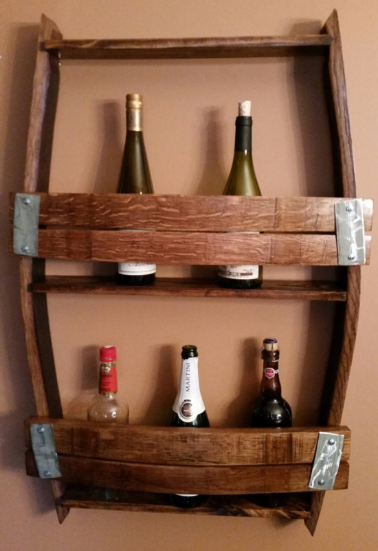 A wooden wine rack by Sharon Knapp holds several wine bottles.