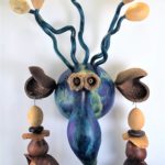 Hand-painted gourd figure with large antennae and ears with a long nose, and earrings by artist Bob Lehman.