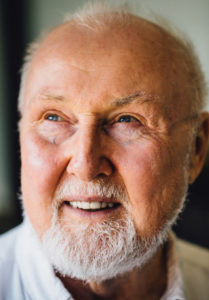 Headshot of Paul J. Stankard smiling with his front teeth and looking to the left by Theodore H.