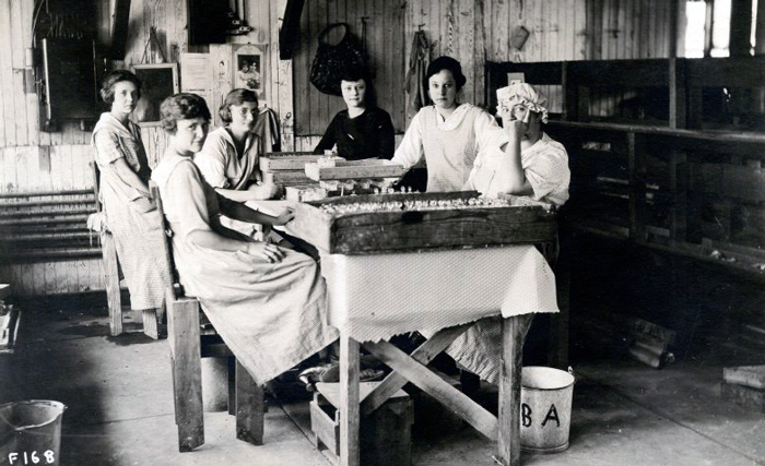 Wheaton Grinding Room, c1920. Black and white photo of 6 women working in the grinding room.