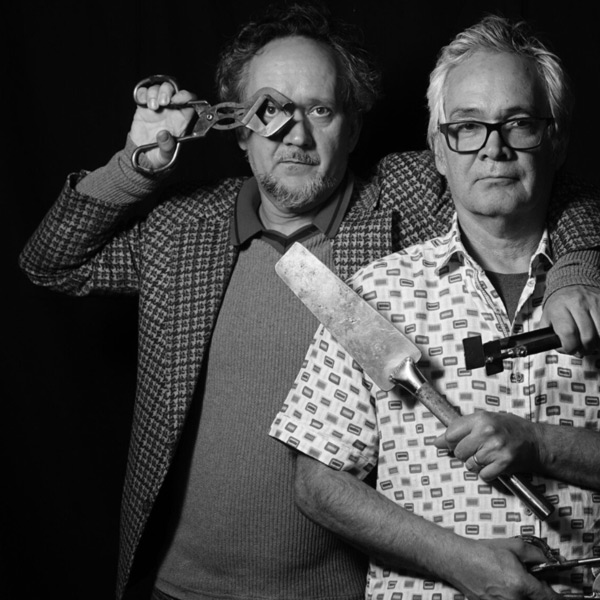 Black and white photo of Einar and Jamex De La Torre standing closely together, holding their tools.