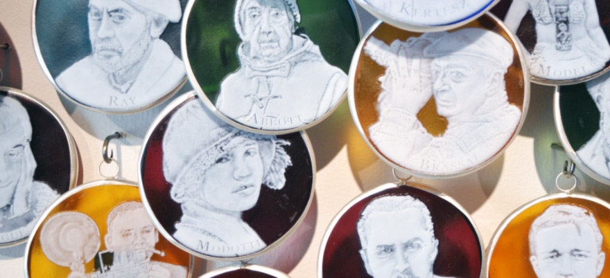 Colored glass circles with white portrait etchings of various peoples.