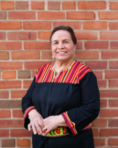 Julia Garcia standing in front of a red brick wall.