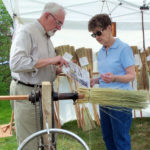 Dr. Sam Moyer, known as “The Jersey Jerry Broomsquire,” shows his wares to a customer.