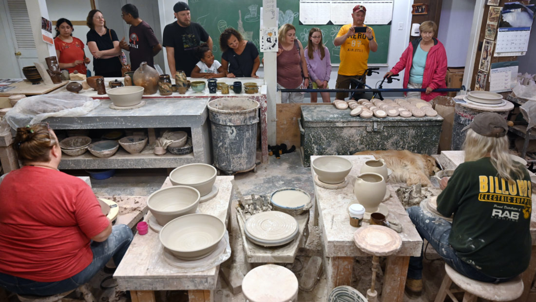 Head Potter Terry Plasket and Associate Potter Phyllis Seidner demonstrate in front of a crowd of visitors.