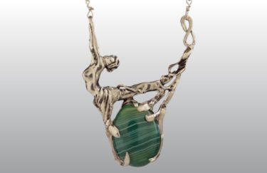 A silver necklace, shaped like a woman and branch, by Harriet Forman Barrett.