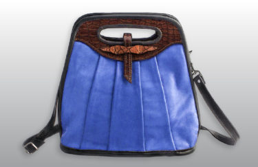 A rich blue leather bag with a red brown leather handle by Frank Westfall.