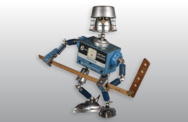 A blue robot made with found objects like a battery charger and a ruler. Created by Brian Marshall.