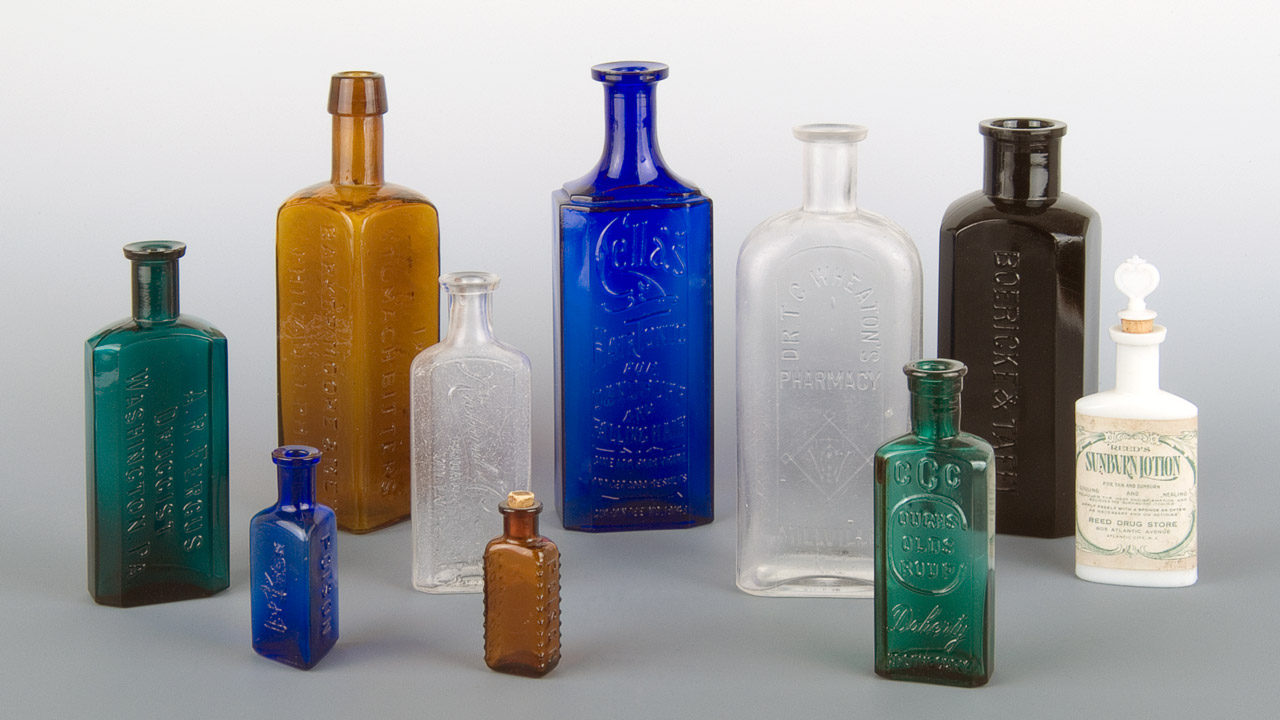 A grouping of colorful glass bottles of different sizes.