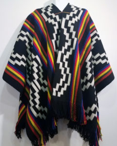 A black poncho with white designs and stripes of rainbow colors.