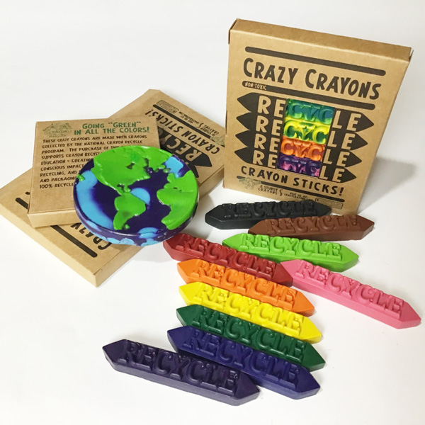 There are two boxes of recycled crazy crayons boxed and unboxed and arranged on a white workspace.