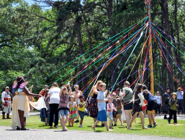Fantasy Faire 2019 attendees and actors participate in maypole dance with other Faire attendees admiring on the sidelines.