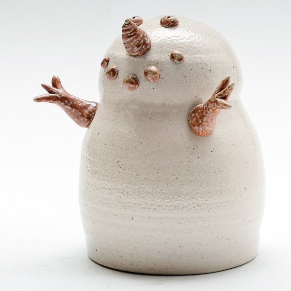 An item from the Holiday Studio Sale. This is a small ceramic snowman by potter Tessa Carlton. The snowman has brown and white spotted arms, with 5 dots as a smile, two eyeballs, and a nose.