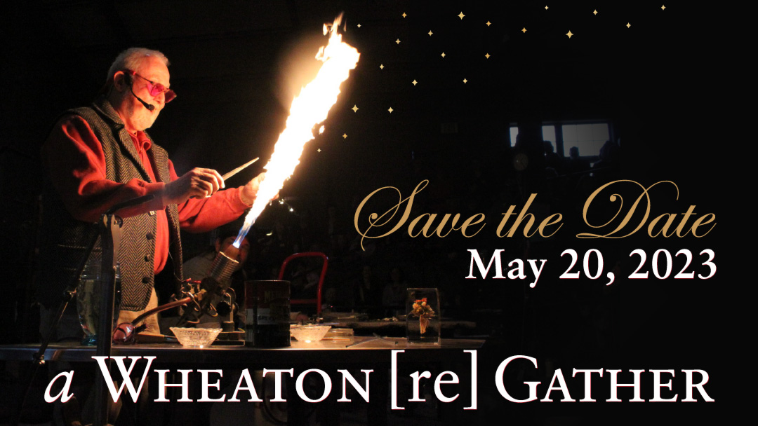 A digital banner for "a Wheaton [re] Gather" is displayed at the bottom of the image. "Save the Date: May 20, 2023" is on the right. Paul Stankard, a middle-aged man with white facial hair & wearing a grey vest over a red long sleeve, is fusing glass over a torch in front of a darkened WheatonArts Glass Studio.