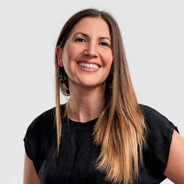 This image is a headshot of 2023 creative glass fellow Josefina Munoz Torres, who is wearing a black shirt, has long hair, and is smiling at the camera.