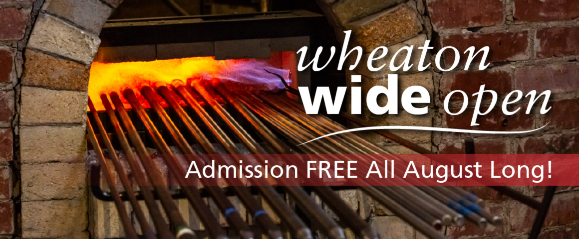 The image shows a banner that reads "Wheaton Wide Open" in large white text in the upper right corner. A long horizontal red rectangle sits underneath with white text inside that reads "FREE Admission All August Long". A burning brick heating chamber is pictured behind the text with seventeen glass blowing poles sticking outside of the opening.