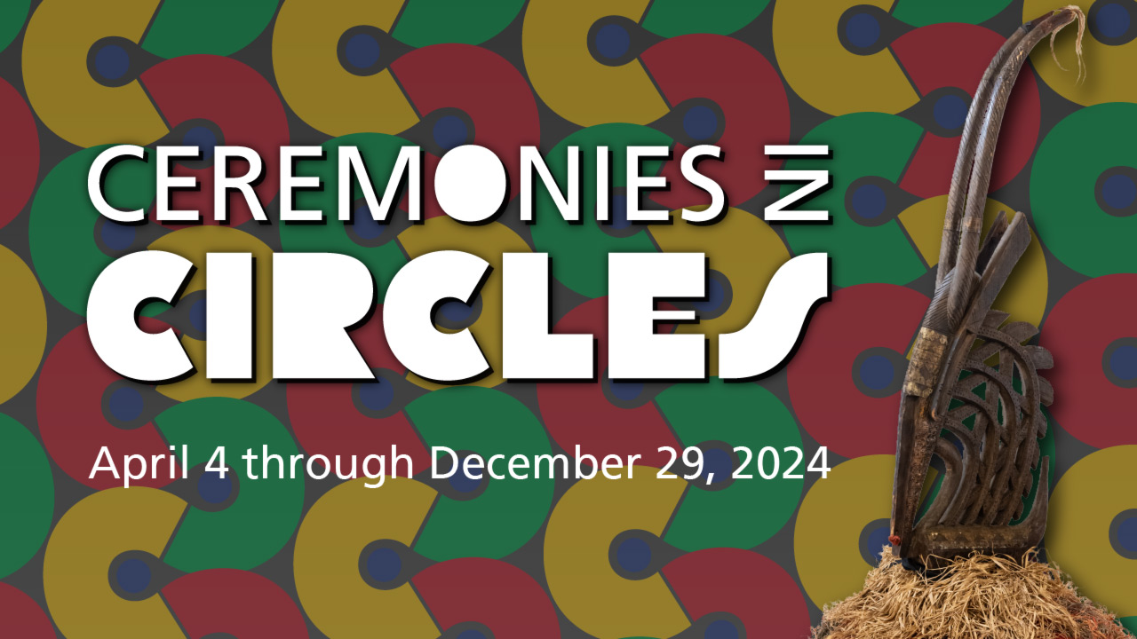 Banner for the "Ceremonies in Circles" exhibit. The background is comprised of yellow, red, and green thick "c"-shaped half circles that connect with each other at the end of the half. The shapes mirror each other as they make a vertical curving pattern in six rows throughout the banner. The colors of the shapes follow a green, yellow, and red pattern. Each shape has a small blue circle in the center gap. The banner also has large white text in all capital letters that read "Ceremonies in Circles". The center "O" in ceremonies is filled in with white o that it looks like a circle. The word "IN" is turned on it's side so that it is facing "Ceremonies". The "Cs" in "Circles" look like the the shapes from the background and the gaps of the "R" are also filled in. Under this title is smaller white text that reads "April 4 through December 29, 2024". On the right side of the text is a piece featured in the exhibit resting on top of a small pile of straw.