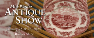 Image of the banner for the 2025 WheatonArts Mid-Winter Antique Show. The background image is blurred, but the right side of the image is in focus and shows a close-up of a brown rack of red and white antique plates with detailed floral designs around a landscape in the center. Above the blurred section, on the left side of the banner, is white text that reads "Mid-Winter Antique Show". There is smaller white text underneath this that reads "January 25 & 26, 2025 Rain or Shine".